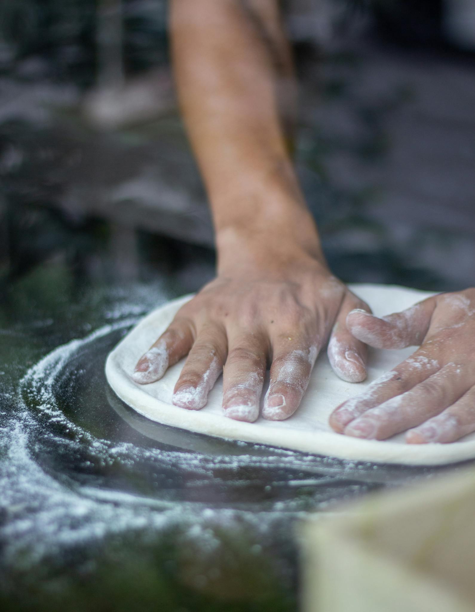 Close-up of hands kneading dough on a floured surface, ideal for cooking and baking themes.